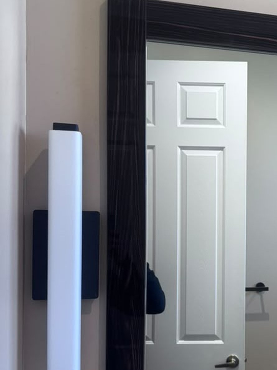 LED wall sconce lighting beside a framed vanity mirror in a bathroom remodel