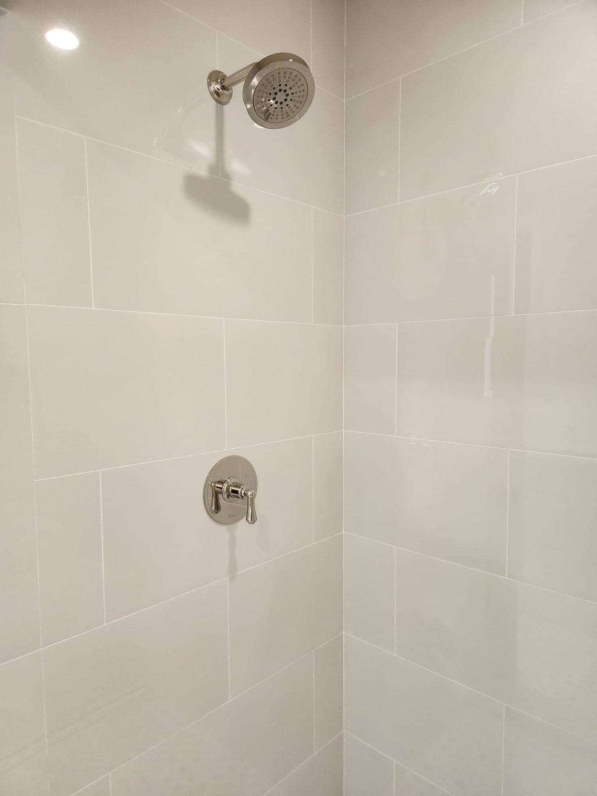 Tiled walk-in shower with rain showerhead and single-handle mixer valve