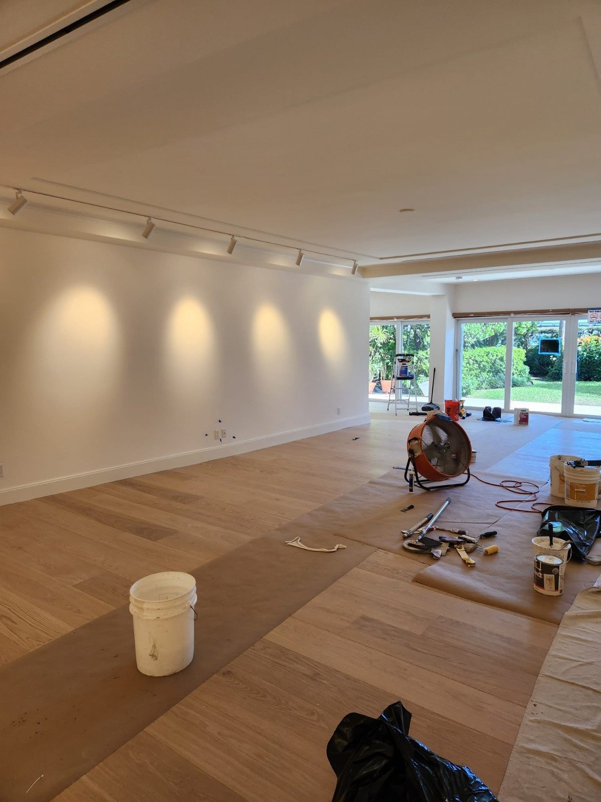 Wood flooring being installed in a freshly painted open living area