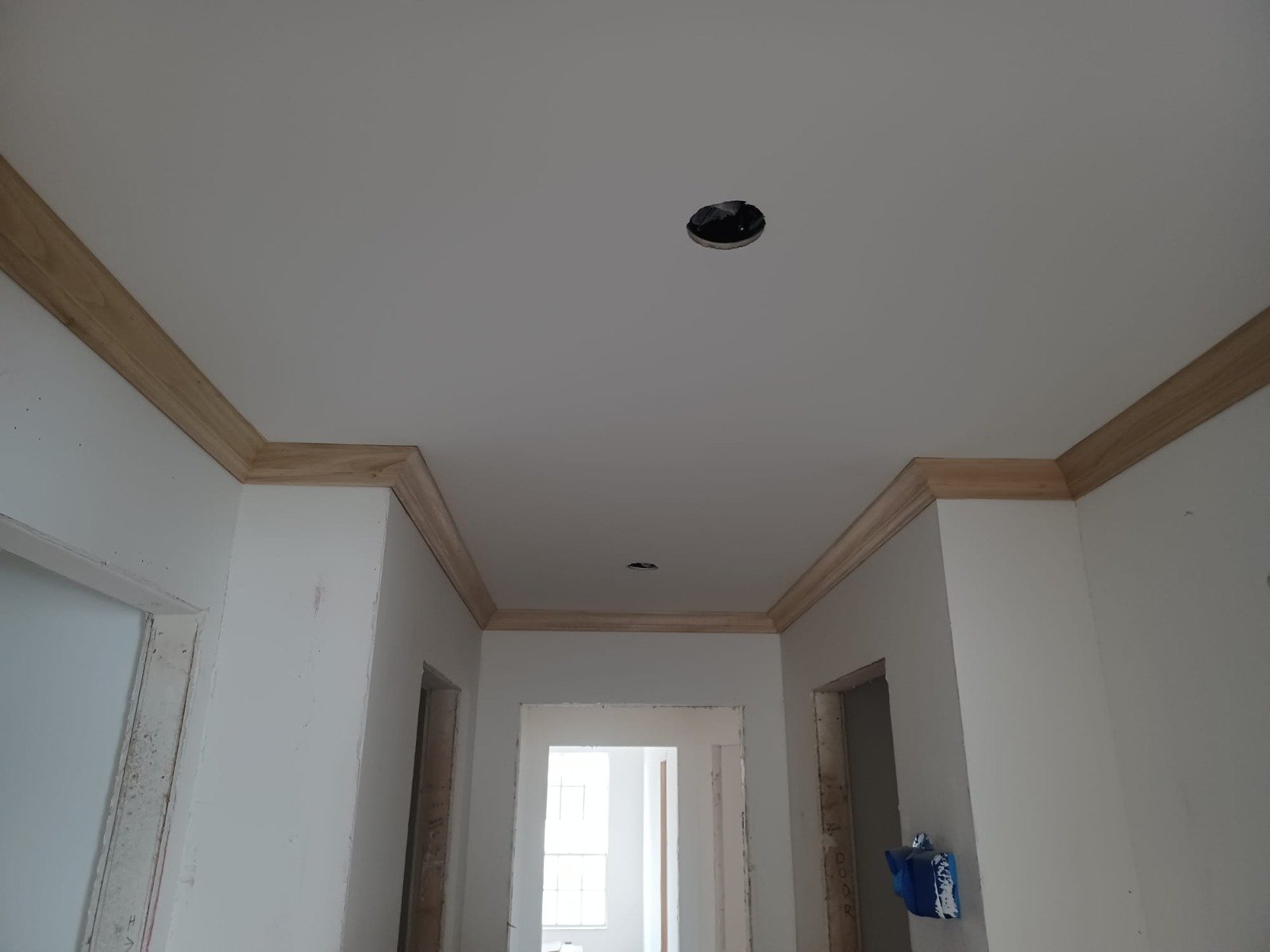 Crown molding and door trim finished in a remodeled hallway