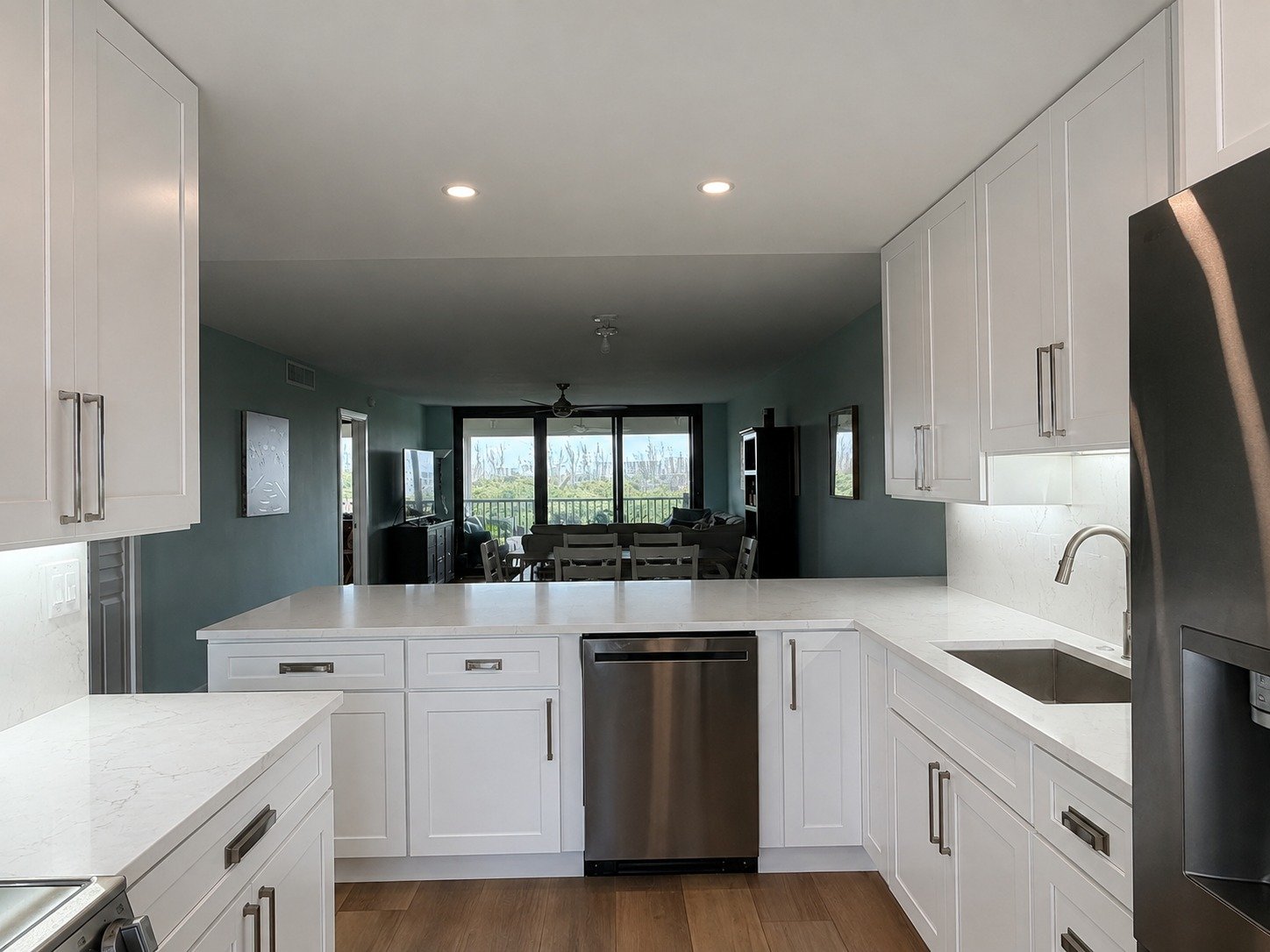 Finished kitchen with white cabinets, quartz island and stainless appliances