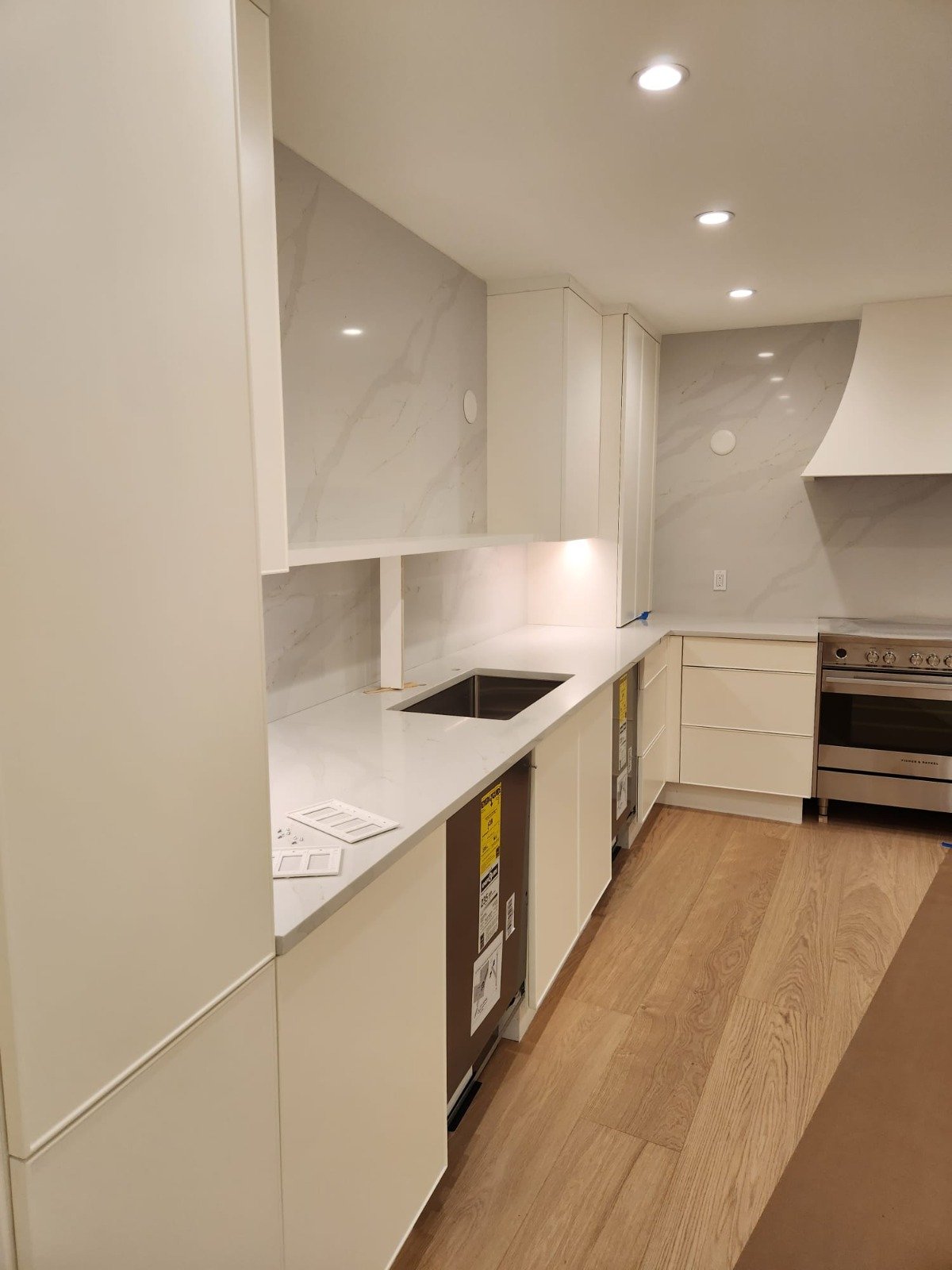 Full-height backsplash and wood flooring in a new kitchen