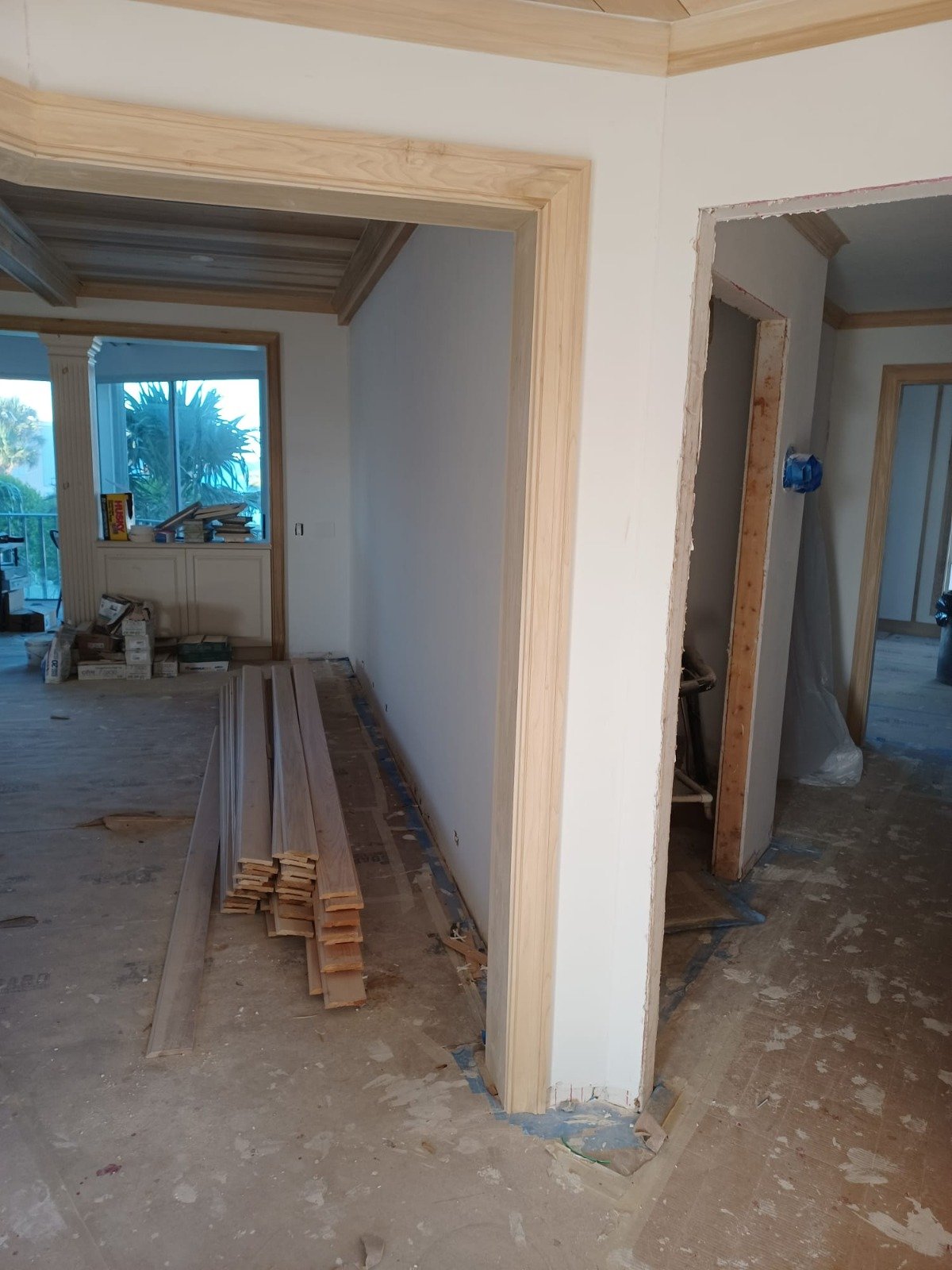 Home mid-renovation with framing exposed and lumber staged in the hallway