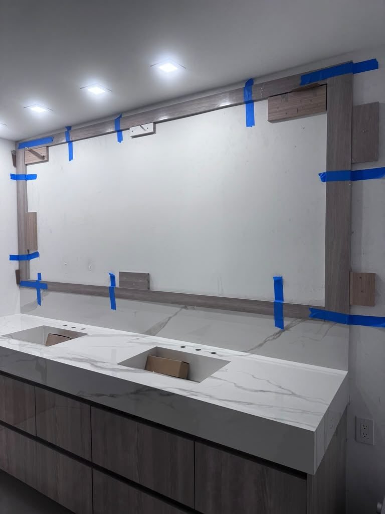 Double vanity with a marble-look quartz top and undermount sinks being installed