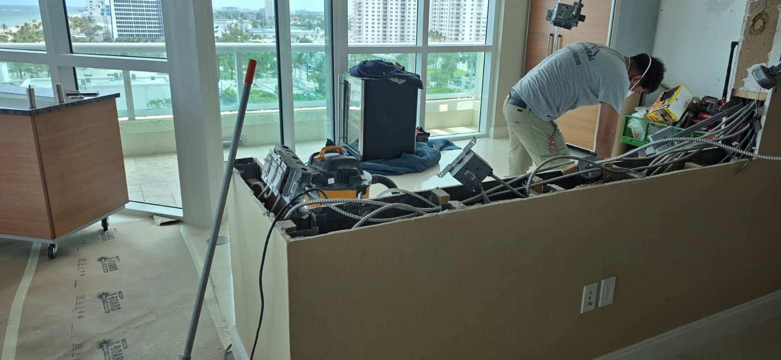 Condo kitchen being opened up and prepped for new cabinets in a high-rise with water views