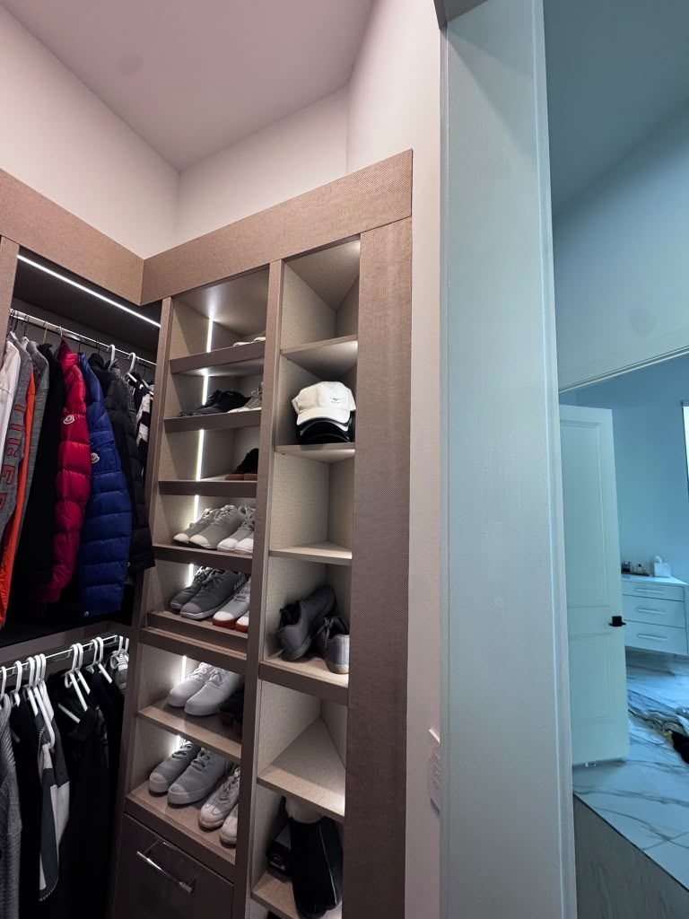 Custom closet with built-in shelving, shoe cubbies and lit hanging sections