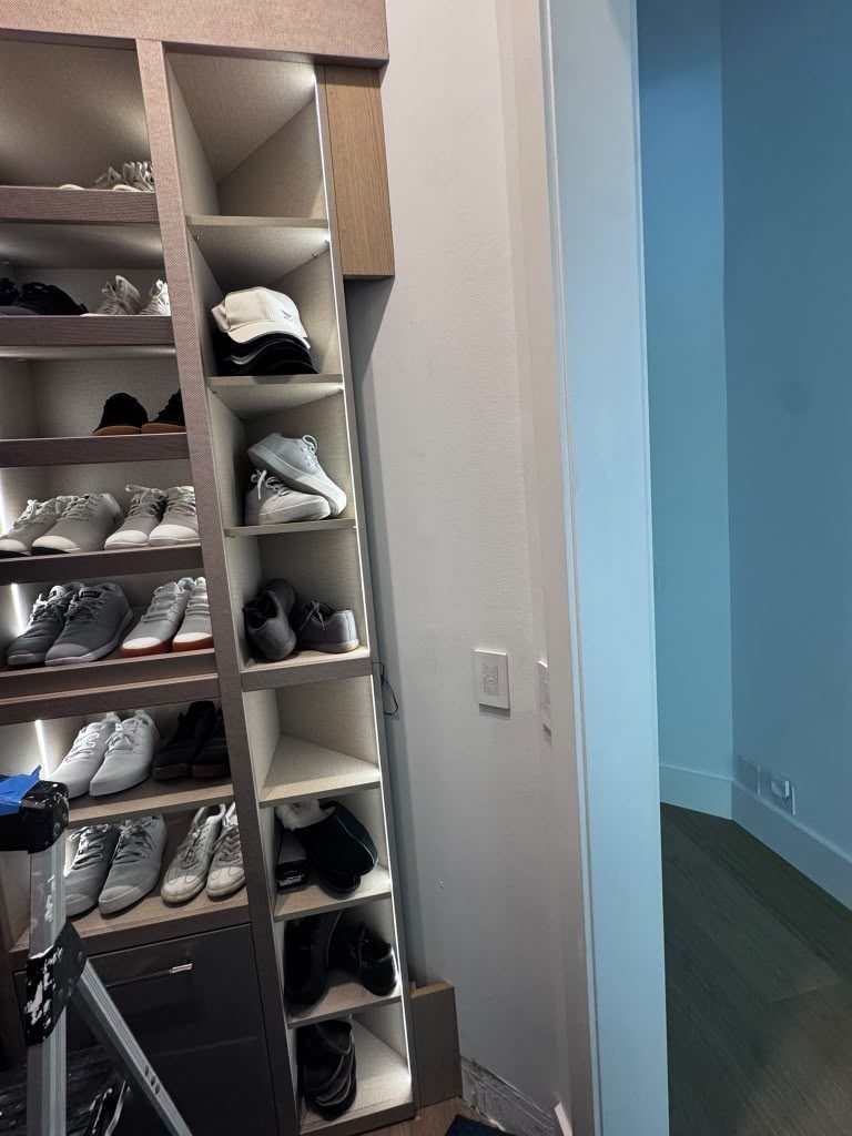 Custom closet with lit shoe shelving and built-in cubbies