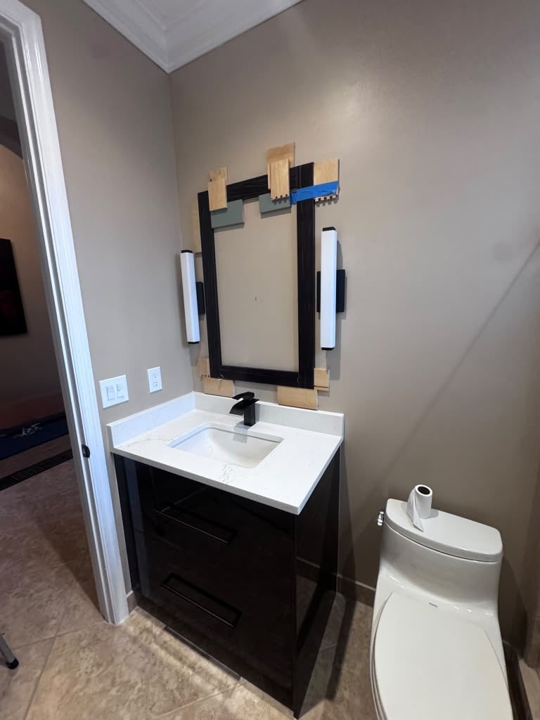 Dark bathroom vanity with a white quartz top and undermount sink