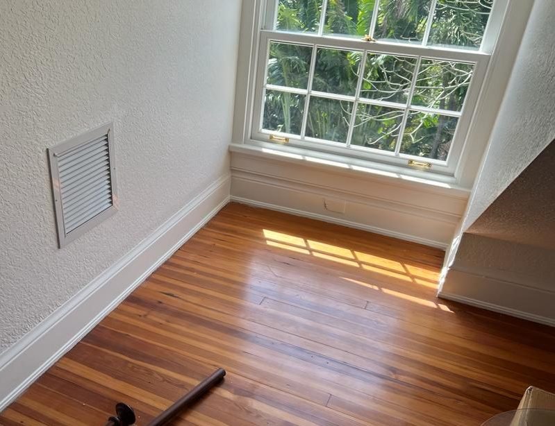 Heart pine floor with a fresh finish under a double-hung window
