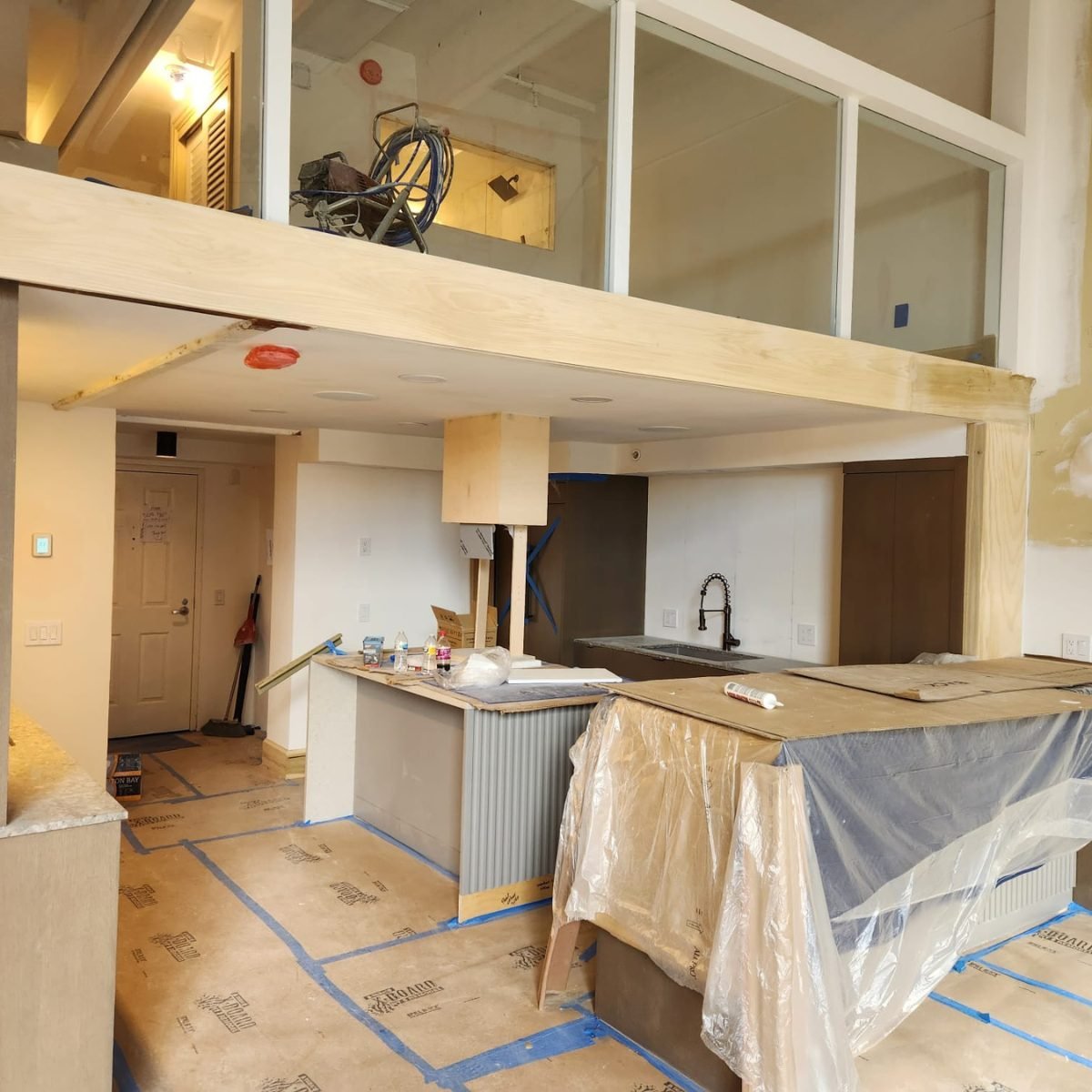 Kitchen island and base cabinets taking shape under a new loft during a remodel