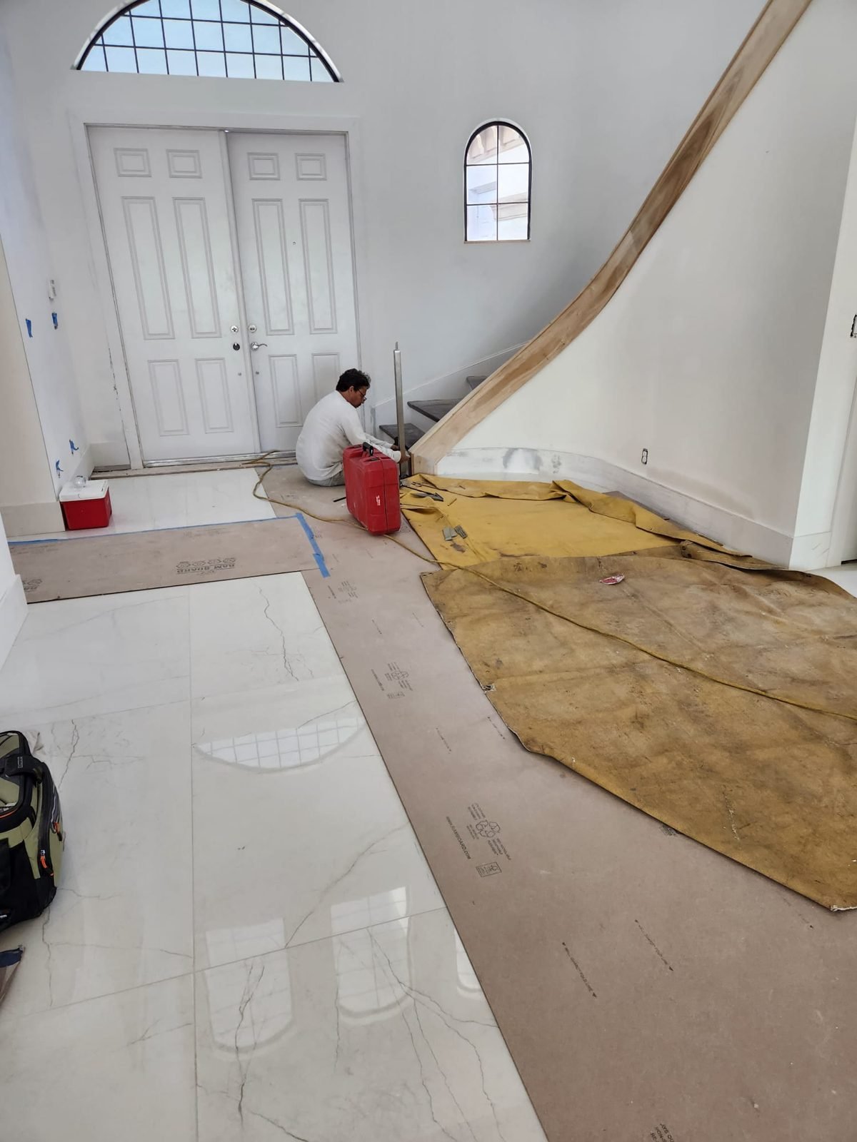 Glossy marble-look porcelain tile flooring laid through a two-story foyer