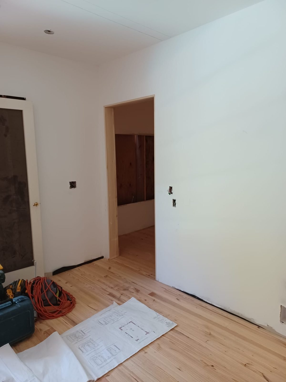Pine flooring installed through connected rooms during a renovation