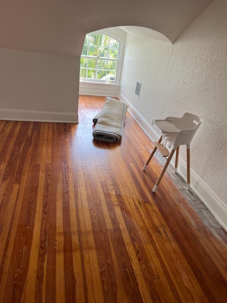 Refinished heart pine floor in a room with an arched window
