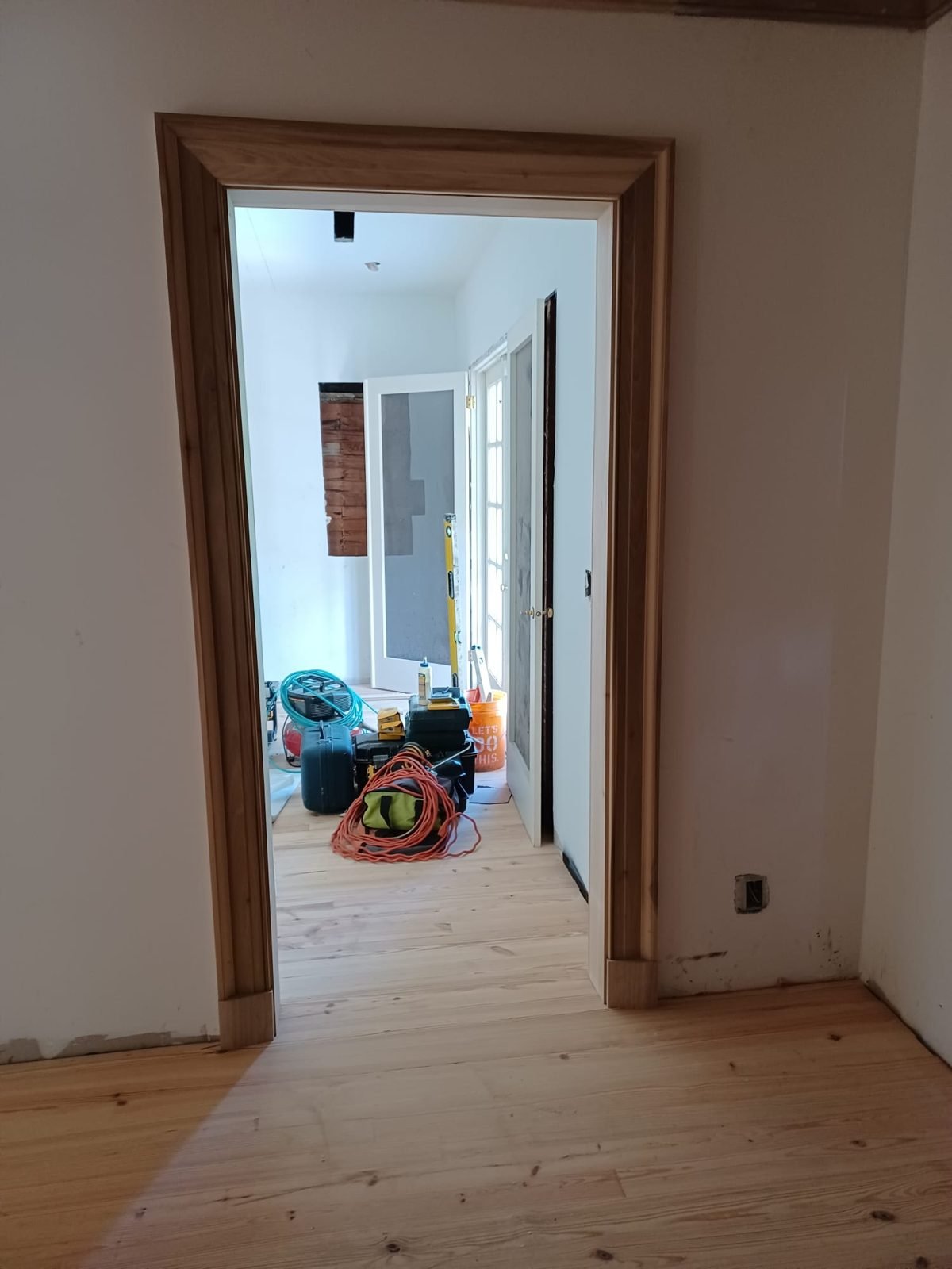 Wide wood door casing finished over a new pine floor