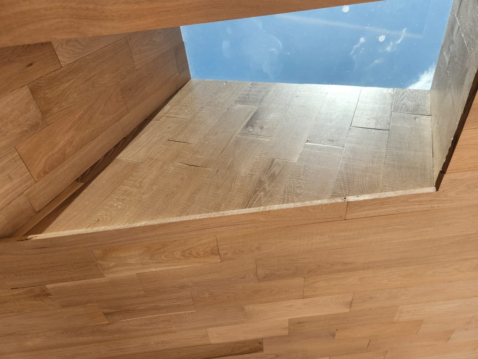 Oak flooring wrapped into a stair opening with a flush nosing at the landing